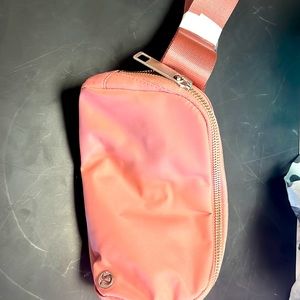 Brand new lulu lemon bag belt in a coral color. Tag is still on bag.